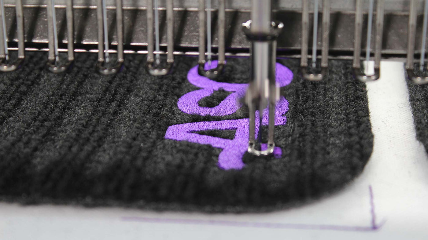 Close-up of active stitching threading the ASC logo into smart textile fabric