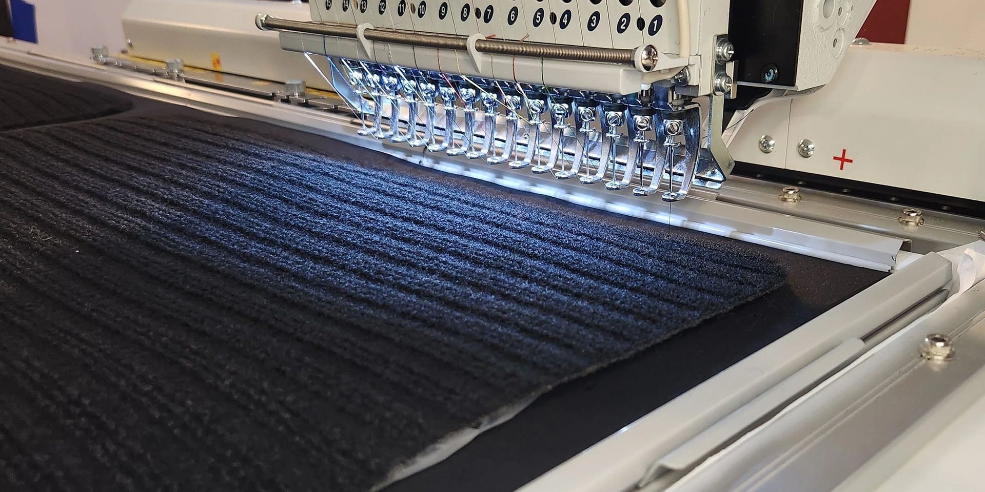Industrial embroidery machine at ASC's Woodinville facility stitching conductive sensor threads into smart textile mats